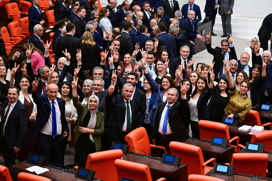 Lawmakers of the pro-Kurdish Peoples’ Equality and Democracy Party flash V-signs as they pose for a group picture after voting on a bill establishing a legal framework for the disbandment of the Kurdistan Workers Party at the Turkish parliament in Ankara, Aug. 10, 2026. (Reuters)