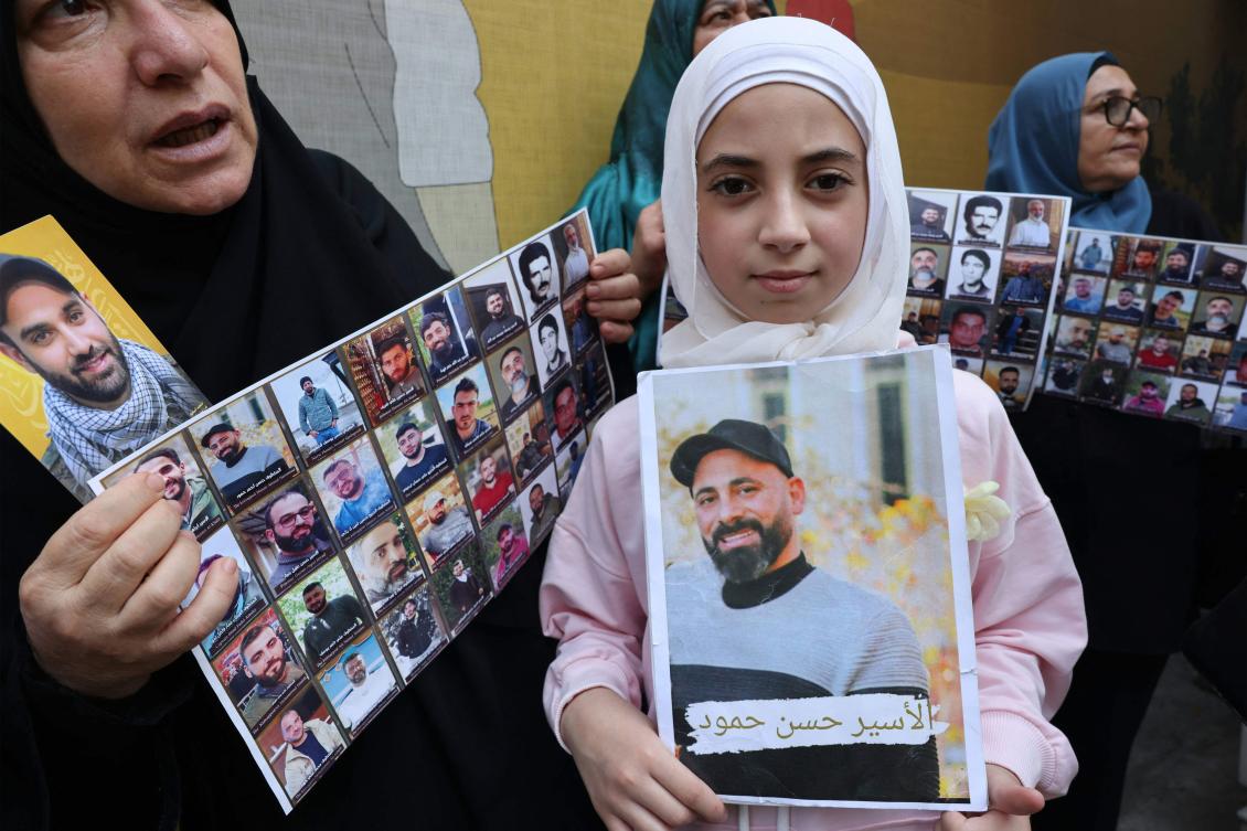 Family members of prisoners and detainees in the Israeli prisons carry the pictures of their relatives during a solidarity protest called for by the Committee of Representatives of Prisoners and Liberated Persons from Israeli prisons, outside the International Red Cross headquarters in Beirut. (AFP)