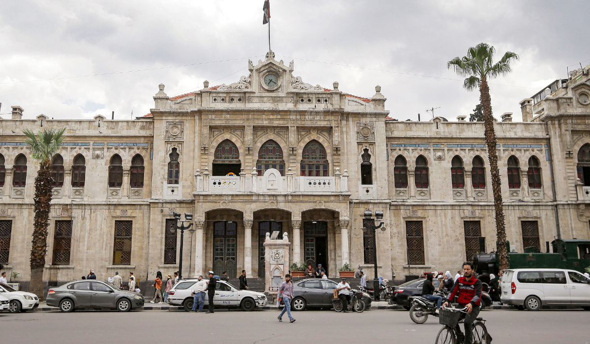 A man cycles past the building of Hejaz Station, the former main railway station in the centre of Damascus on April 14, 2024. (AFP)