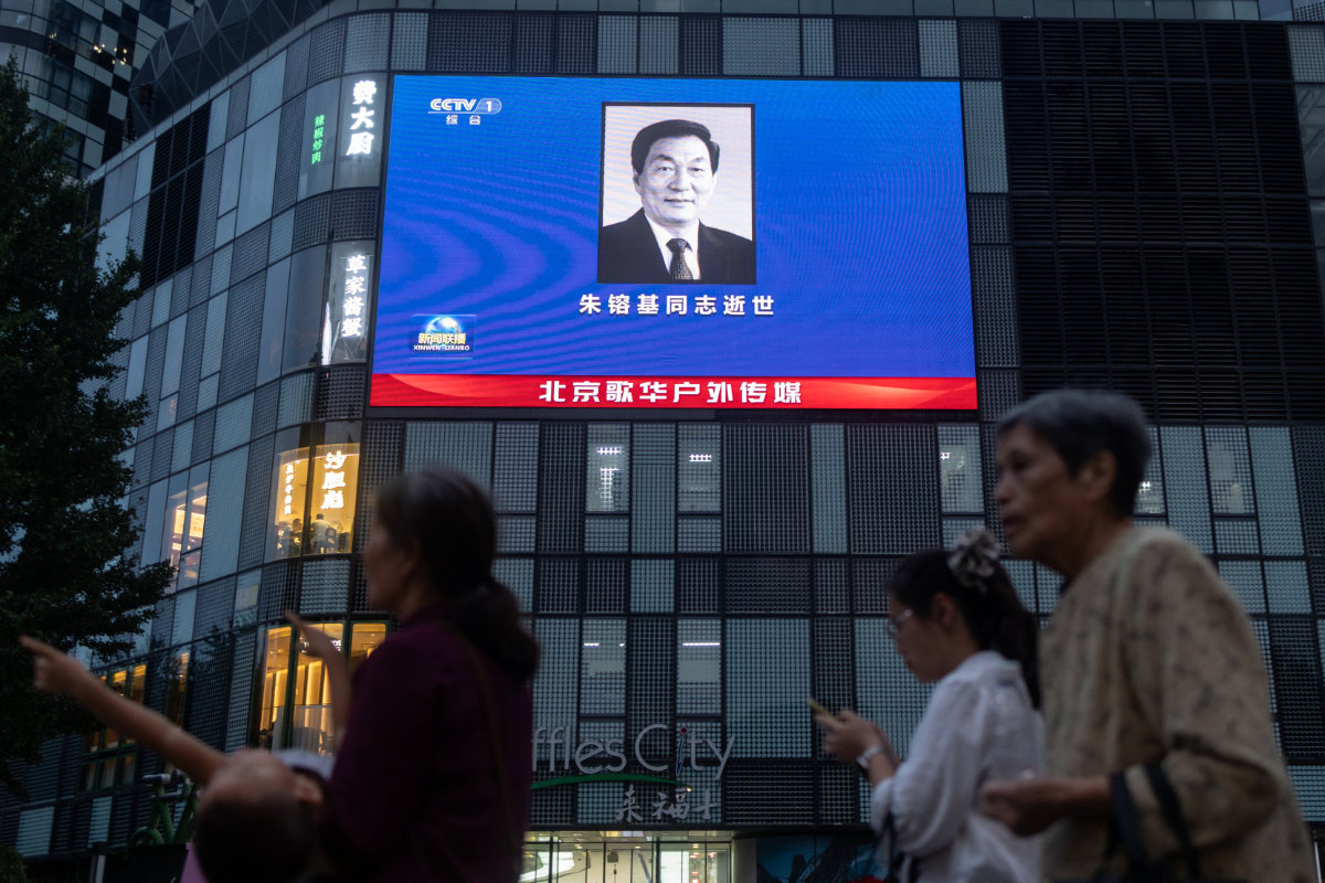 People walk next to a shopping mall featuring advertisement screen broadcasting a portrait of Former Chinese Premier Zhu Rongji who passed away in Beijing, China, on August 12, 2026. (Reuters)
