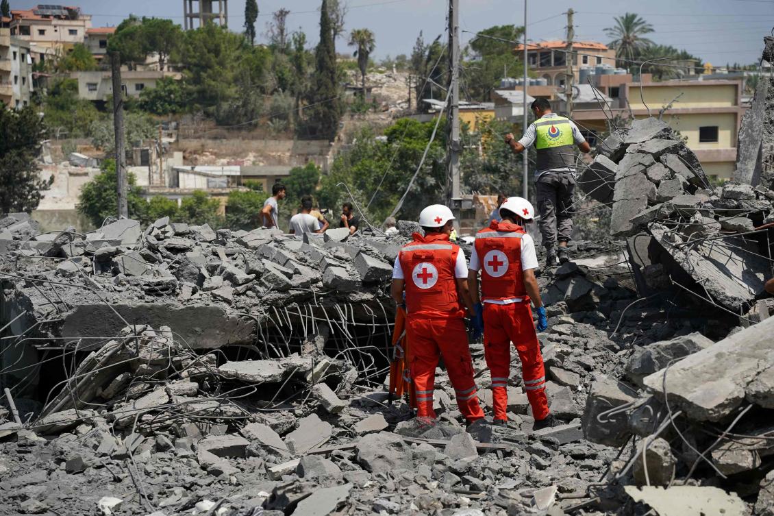First aid responders and residents rush to the site of an Israeli airstrike that targeted the neighborhood in the southern Lebanese village of Deir al-Zahrani. (AFP)