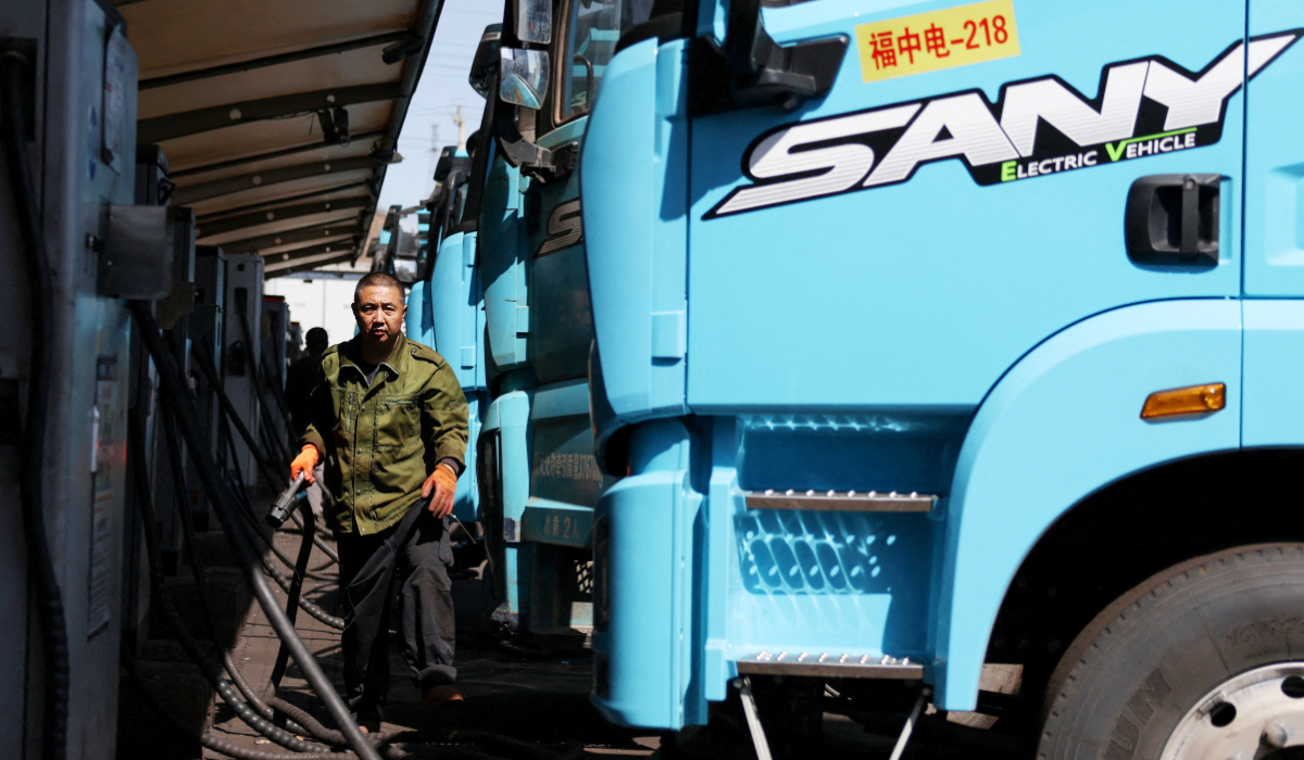 A driver uses a charging station to charge a Sany electric heavy truck at a fleet depot equipped with electric truck charger, in Tangshan, Hebei province, China, April 1, 2026. (REUTERS)