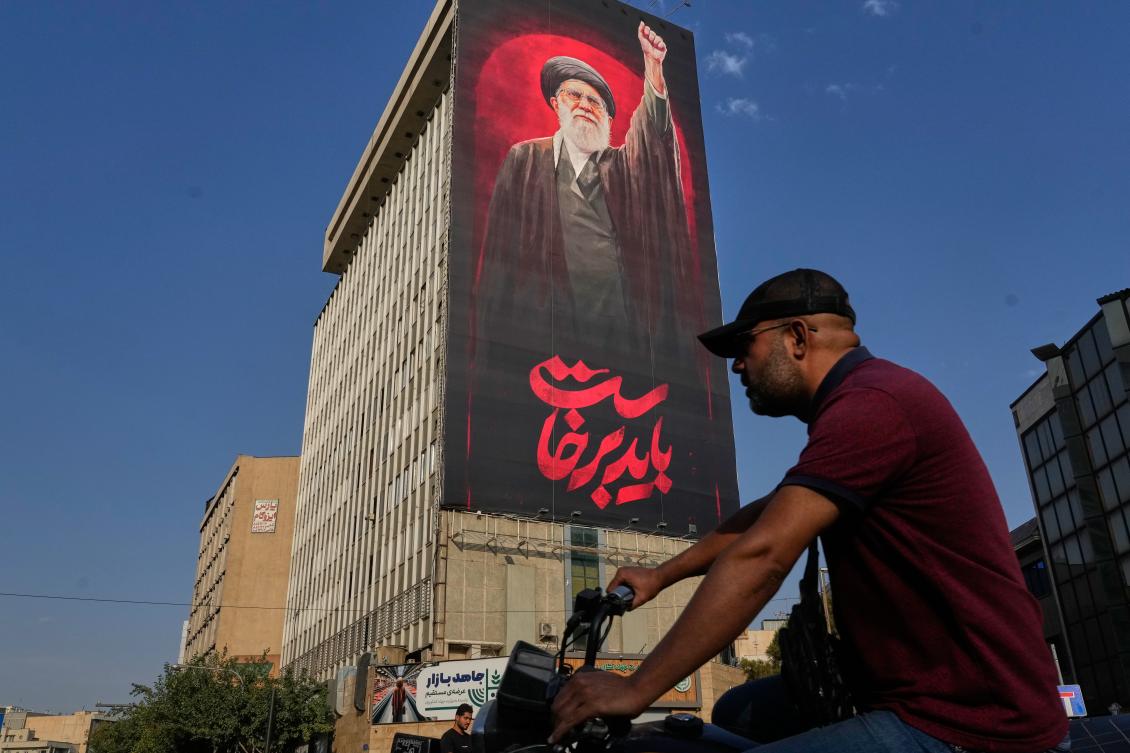 A man rides on his motorbike past a billboard showing the late Iranian Supreme Leader Ayatollah Ali Khamenei, who was killed during the US and Israel strikes on Feb. 28, in Tehran. (AP)