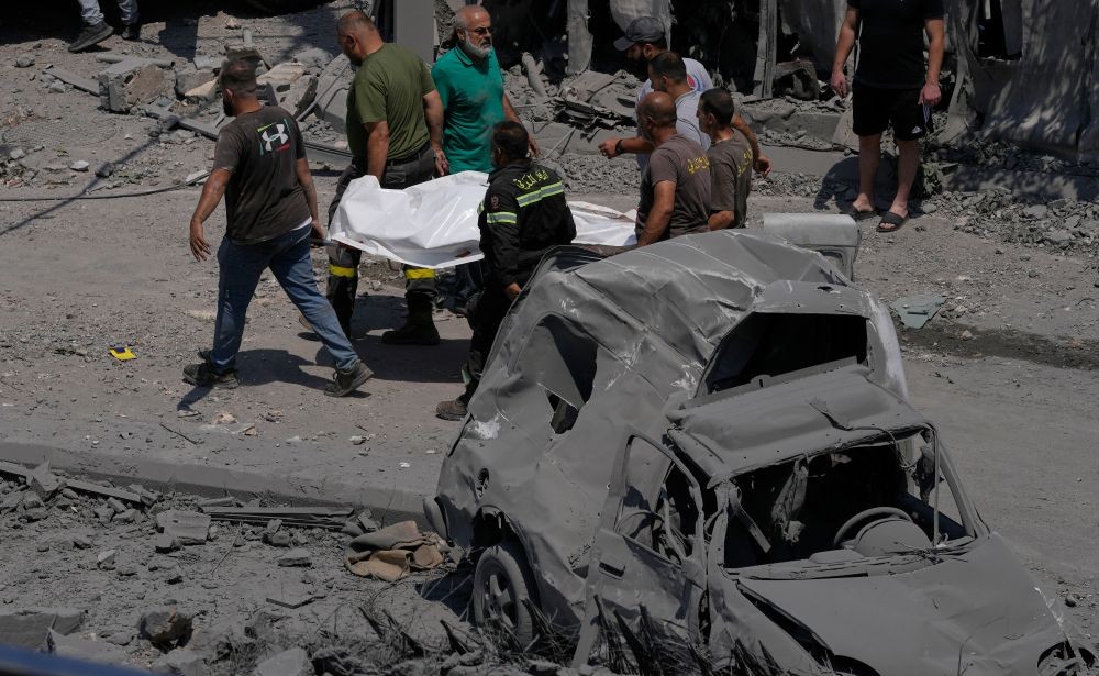 Rescue workers carry the body of a person, who was killed at a house that was hit by an Israeli airstrike, in Deir Al-Zahrani village, southern Lebanon, Saturday, Aug. 15, 2026. (AP Photo)
