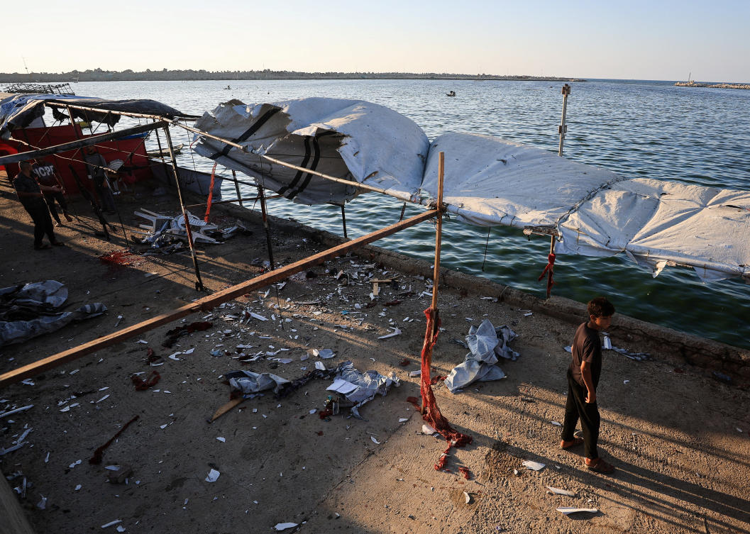 A Palestinian inspects the site of an Israeli strike on a cafe, at the seaport of Gaza City. (Reuters)