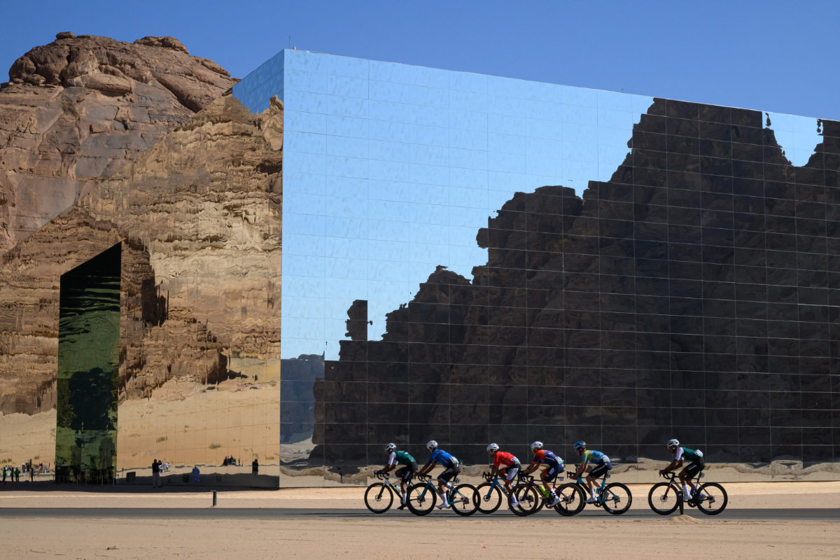 This photo taken on January 28, 2025 shows cyclists riding past the mirror cladding of the Maraya Concert Hall, the world's largest mirrored building designed by Florian Boje of France, co-founder of international architectural firm Giò Forma. (Supplied)