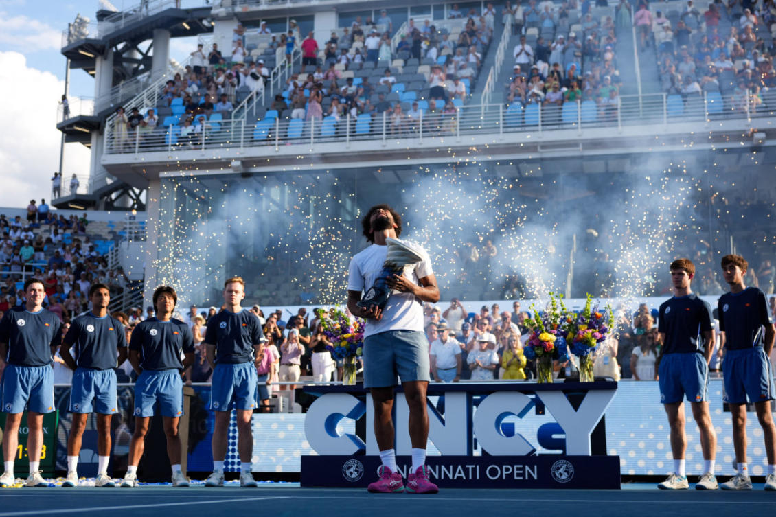 Arthur Fils celebrates with the Rookwood Cup on the court after defeating Frances Tiafoe during the finals of the Cincinnati Open at Lindner Family Tennis Center. M(Aaron Doster-Imagn Images)