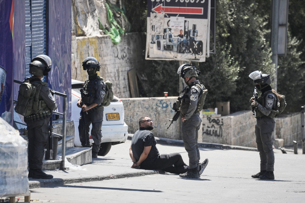 A handcuffed Palestinian man is detained by Israeli border police officers during an army operation in the Qalandiya refugee camp in the West Bank, Tuesday, Aug. 25, 2026. (AP)