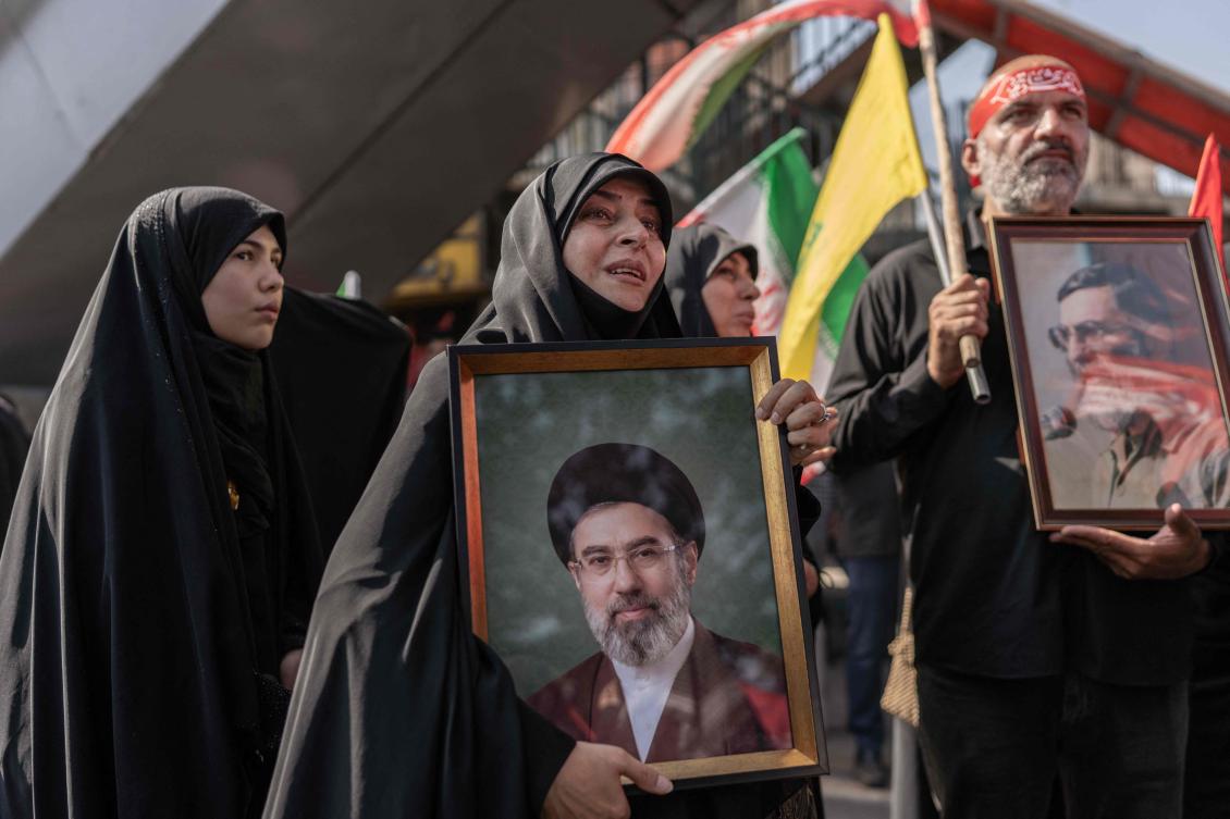 A mourner holds a portrait of Iran’s supreme leader Ayatollah Mojtaba Khamenei as people attend the funeral procession of Iran’s slain supreme leader Ayatollah Ali Khamenei and his family members in Tehran on July 6, 2026. (AFP)