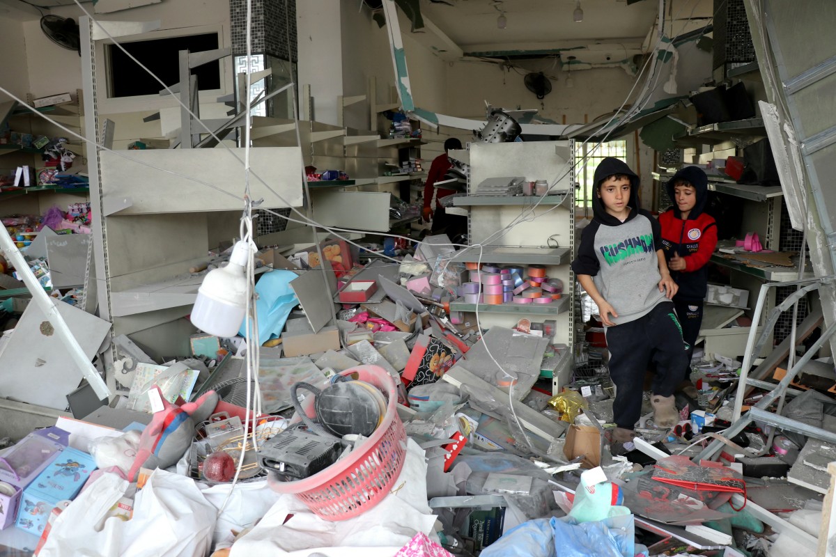 Children walk through a damaged store as displaced residents return to the southern Lebanese village of Srifa on April 19, 2026. (AFP)