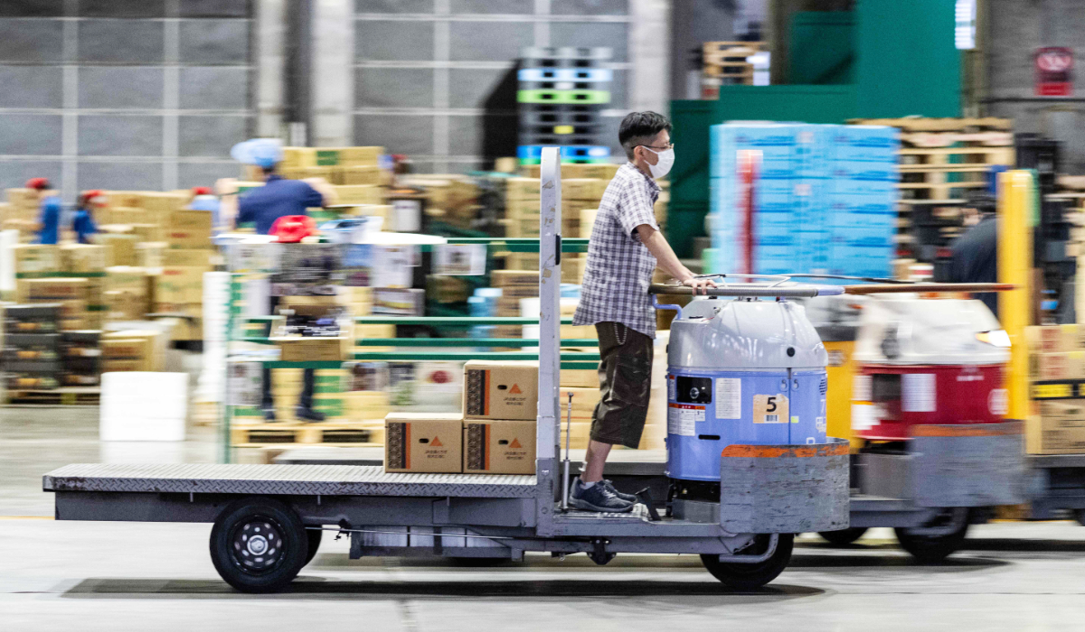 A wholesale market worker transports boxes of vegetables aboard a turret truck at Ota Market in Tokyo on August 29, 2026. (AFP)