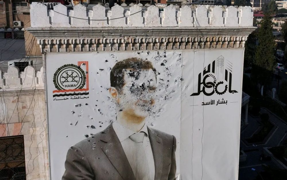 A bullet-riddled portrait of Syrian President Bashar Al-Assad, in Hama, as rebels advanced, Dec. 2024. (AFP)
