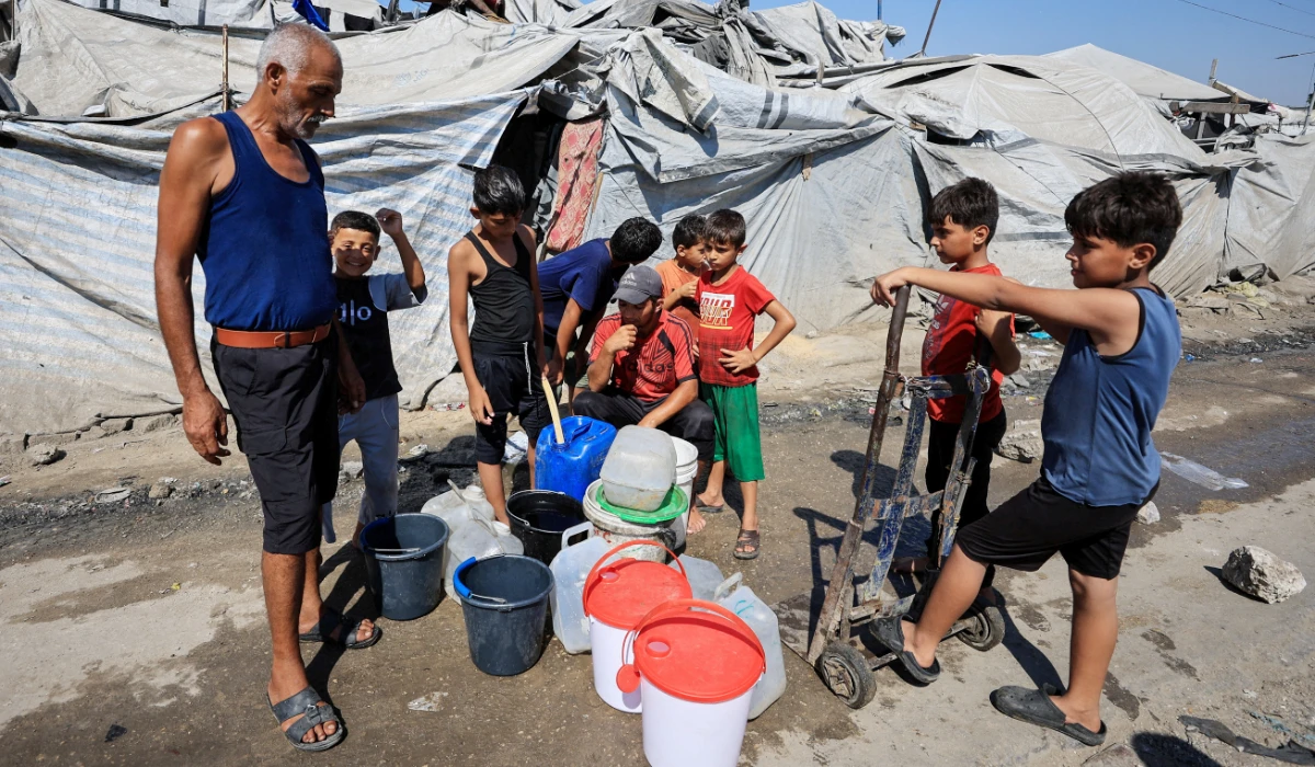Displaced Palestinians gather to collect water at a tent camp in Gaza City, August 9, 2026. (REUTERS)