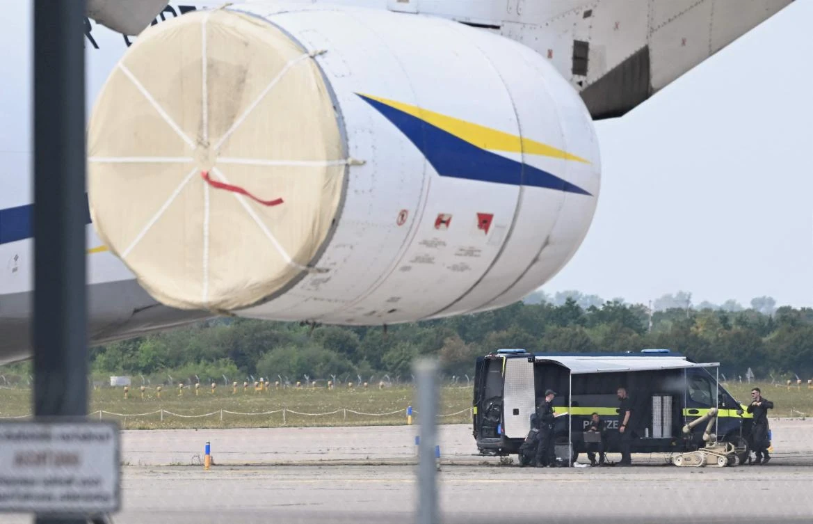 Forensic technicians of the police (R) prepare the deployment of a bomb disposal robot near a Ukrainian aircraft at the German airport Leipzig-Halle in Schkeuditz, eastern Germany, after an explosives-laden drone was found near a Ukrainian cargo plane. (AFP)