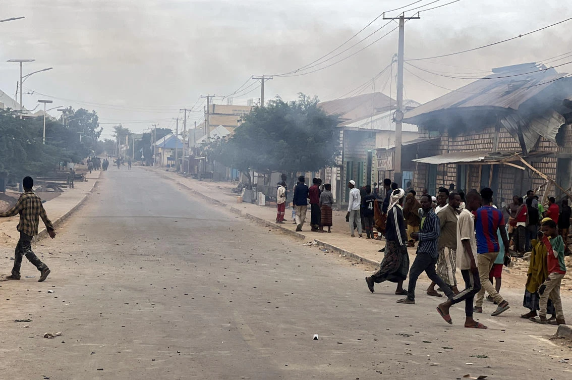 Civilians gather as smoke billows from a shop hit by artillery following clashes between Somalia’s federal troops and armed opposition groups, in Baidoa, Somalia on Aug. 17, 2026. (Reuters)
