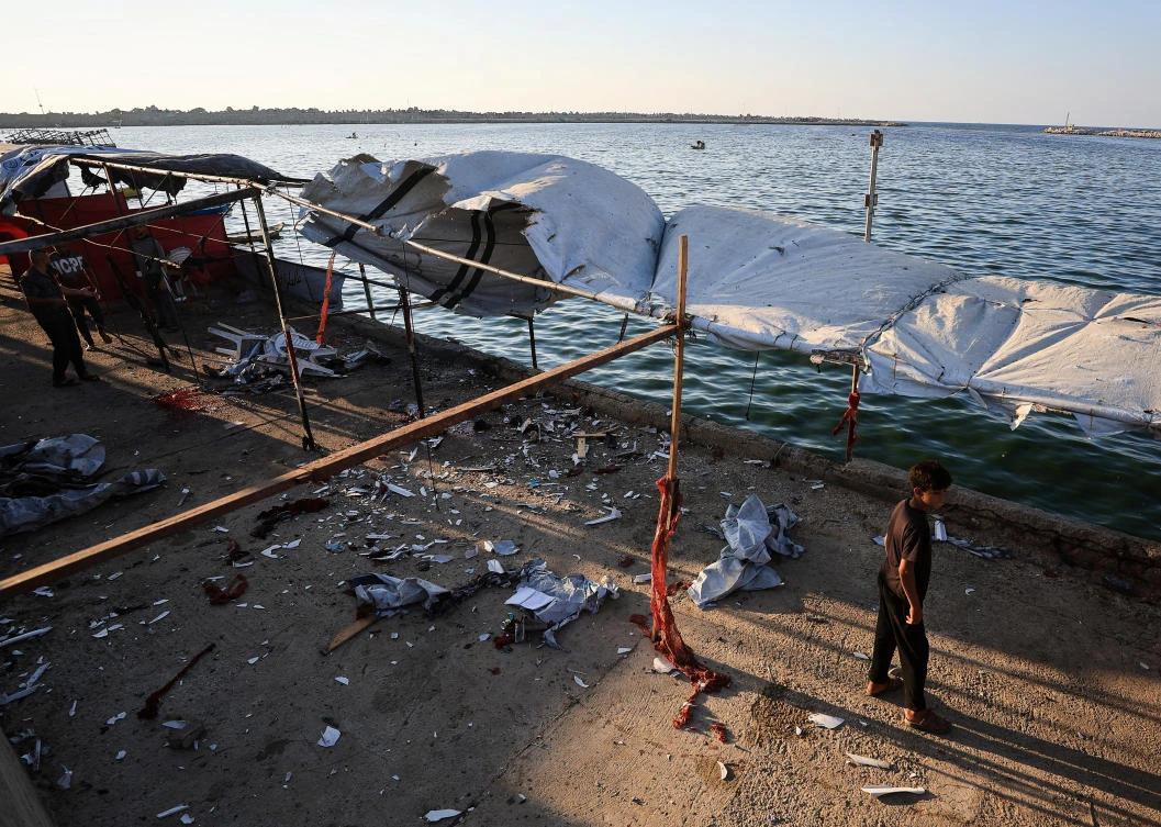 A Palestinian inspects the site of an Israeli strike on a cafe, at the seaport of Gaza City. (Reuters)