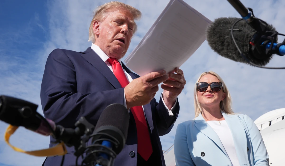 President Donald Trump, left, looks at a document as he speaks with reporters as White House press secretary Karoline Leavitt listens before boarding Air Force One, Friday, Aug. 21, 2026, at Joint Base Andrews, Md., en route to South Carolina. (AP)