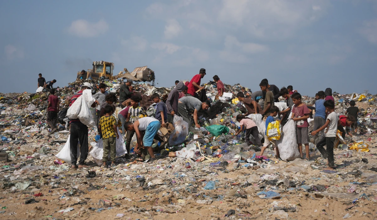 Palestinians search through a garbage dump for combustible materials to use as fuel for cooking due to a shortage of cooking gas, in Deir al-Balah, central Gaza Strip, Saturday, Aug. 22, 2026. (AP)