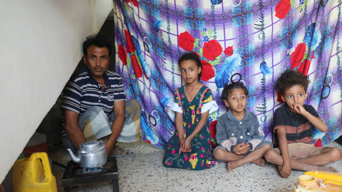 Displaced Yemeni father Ali Hassan looks on while sitting with his children at a school-turned-shelter in Taiz, Yemen, October 15, 2026. (REUTERS/Ebrahim al-Suhaibi) 