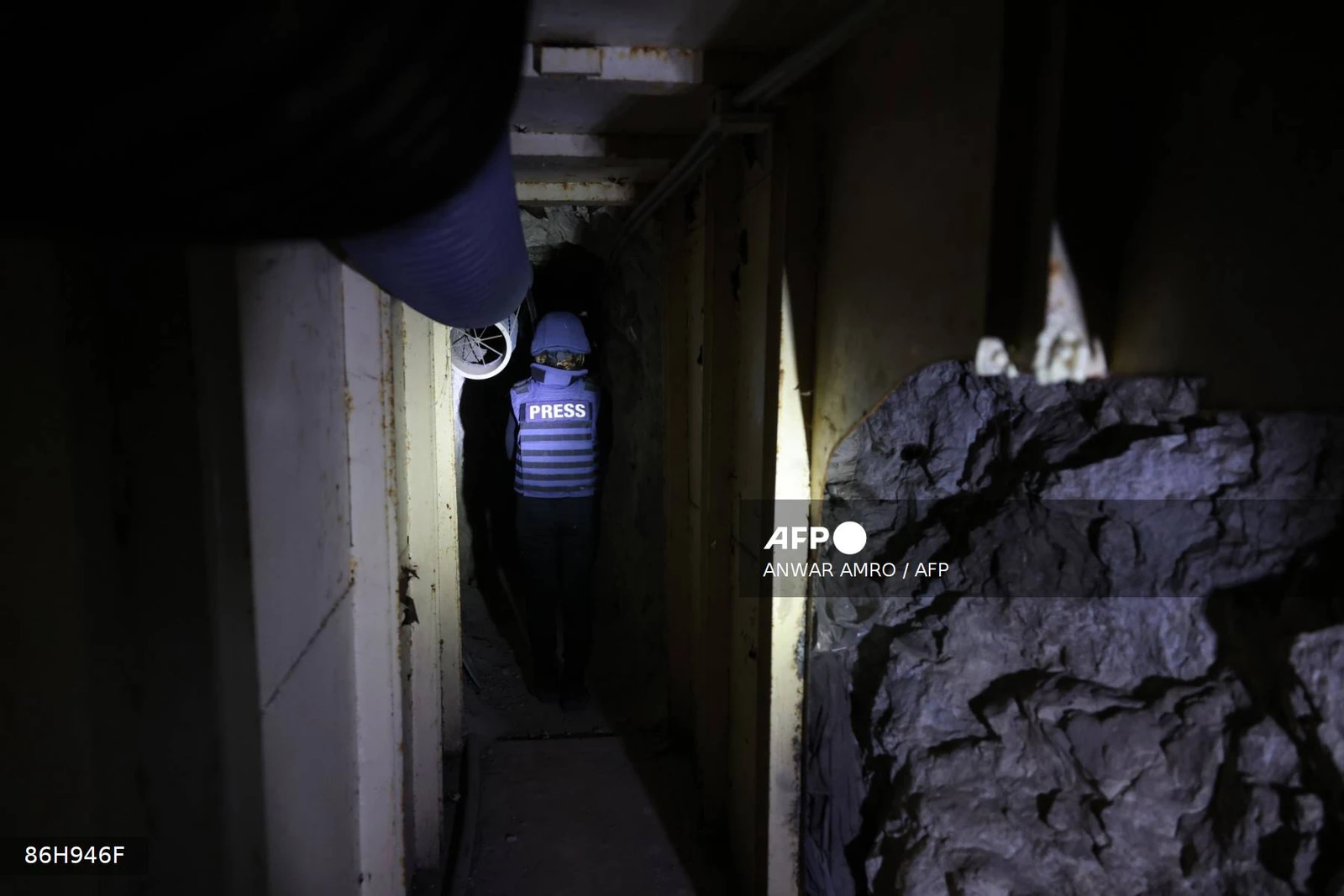 This photograph taken during a press tour organised by the Lebanese army shows a journalist walking through an abandoned tunnel said to have been used by Hezbollah, in a mountainous valley on the outskirts of the southern village of Zibqin, on November 28, 2025. It was the first guided tour the army gave journalists since a November 2024 ceasefire sought to end over a year of hostilities between Hezbollah and Israel. (Photo by ANWAR AMRO / AFP)