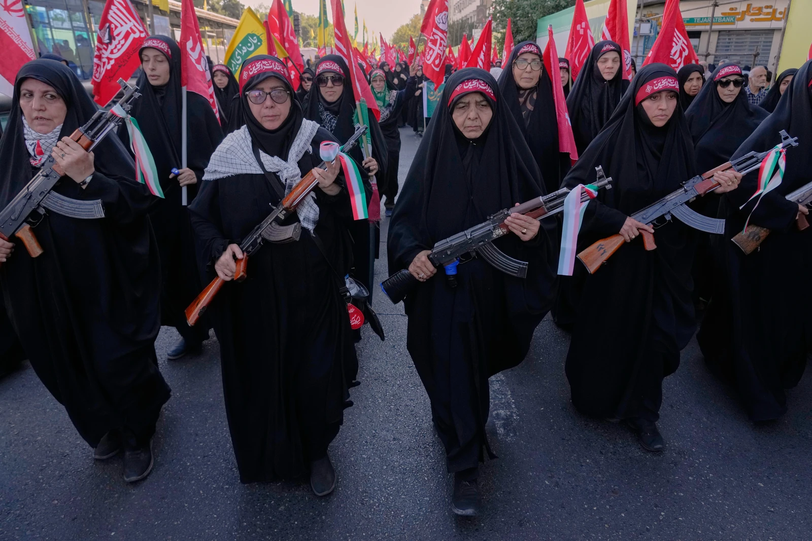 Women affiliated with Iran's Revolutionary Guard carry rifles as they participate in the state-organized military-style parade in Tehran on Friday. (AP)