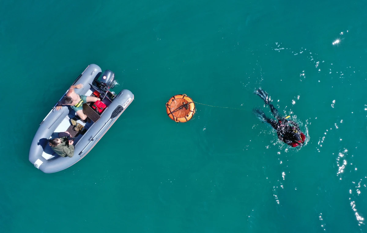 An expedition diver plunges into the waters of Lake Issyk-Kul to explore the underwater site of a submerged medieval city in the settlement of Toru-Aygyr in Kyrgyzstan on September 22, 2026. (Photo by Vyacheslav Oseledko/ AFP)