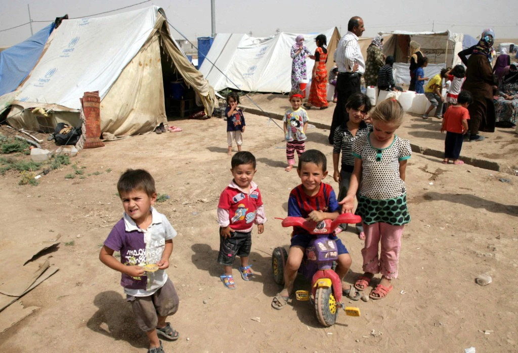 Syrian-Kurdish children refugee play outside tents at the Domiz refugee camp, 20 km southeast of the northern Iraqi city of Dohuk, on June 19, 2013. (AFP/File)