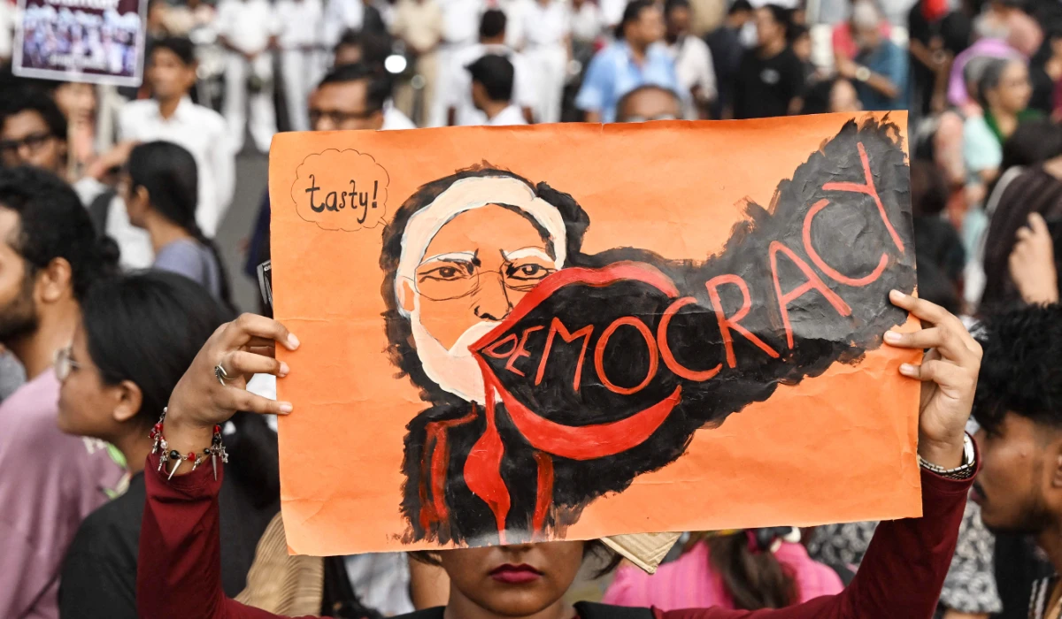 A student activist aligned with left-wing organisations holds a poster of India's Prime Minister Narendra Modi amid the ongoing protest in solidarity with the youth-led Cockroach Janata Party (CJP) demanding the resignation of the countryís Chief Election Commissioner Gyanesh Kumar over alleged voter roll irregularities linked to the "special intensive revision" (SIR), in Kolkata on October 11, 2026. (AFP)