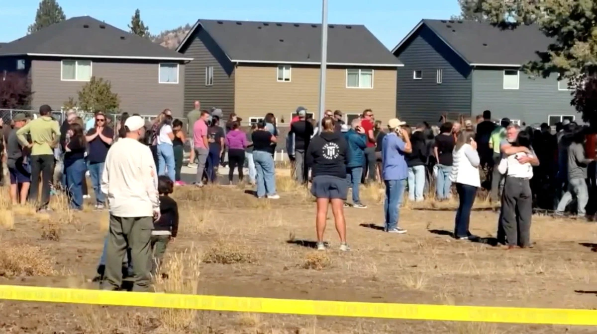 People stand near the scene of a shooting at Silver Rail Elementary School in Bend, Oregon, on October 15, 2026, in this screengrab from a handout video. (ABC affiliate KOHD/Handout via REUTERS)