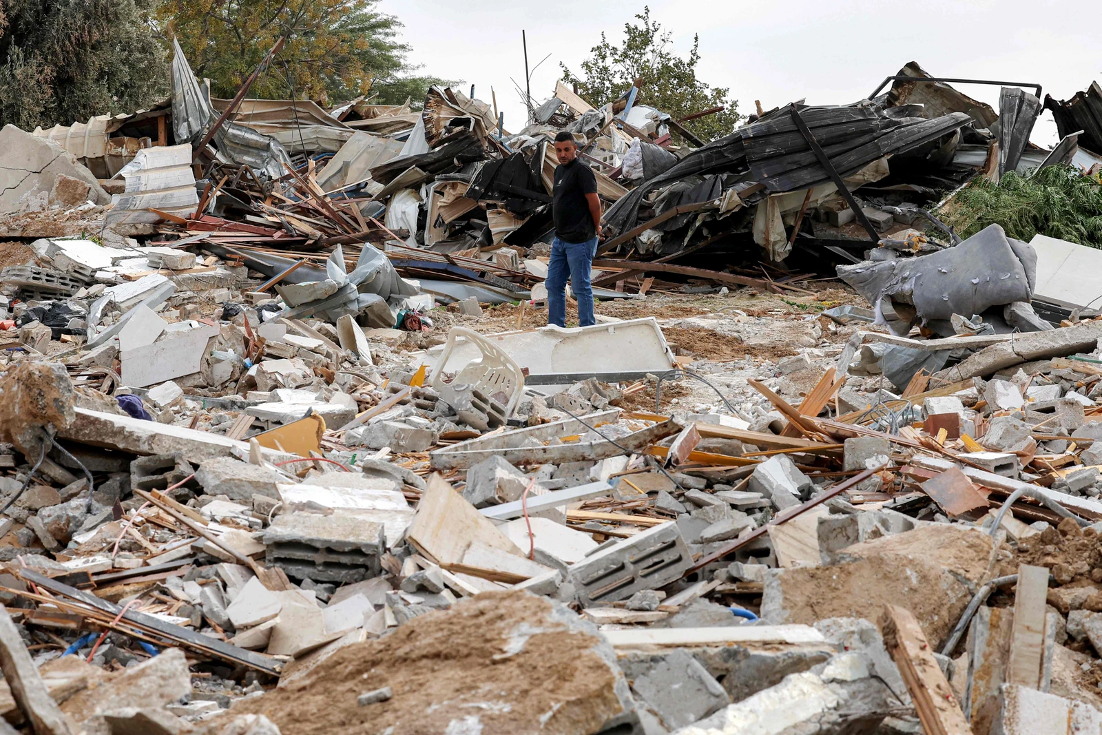 A man walks through the rubble of the destroyed buildings of the Abu Wadi Bedouin community that were demolished for lack of construction permits, in the village of al-Dhahiyah near Rahat in Israel's southern district on October 12, 2026. (AFP)