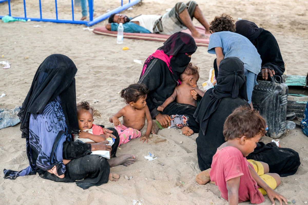 Women and children gather at a temporary shelter for internally displaced people at the Shawkani school, north of Aden in southern Yemen, on September 15, 2026. (AFP)  
