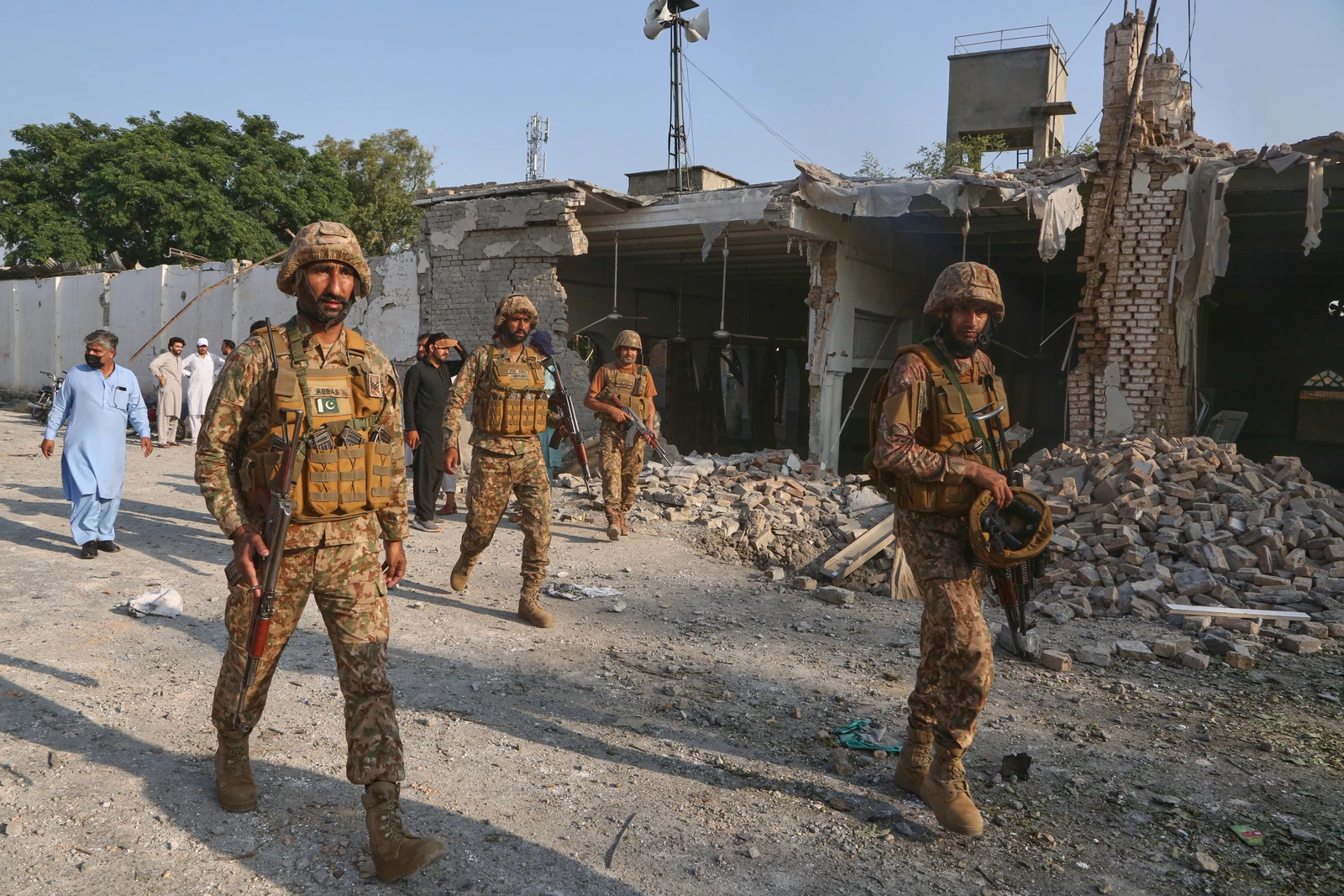 Soldiers walk on the site following a bomb explosion at a mosque in Kohat, in northwestern Pakistan, Friday.
