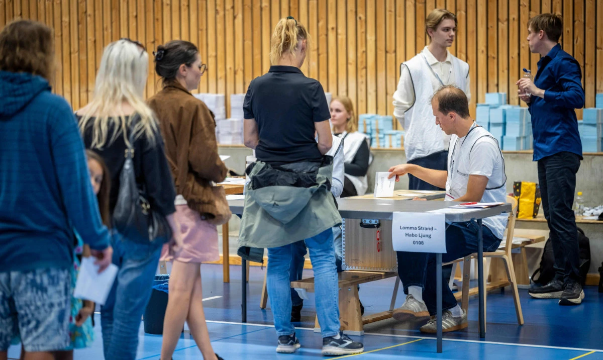 Voters queue to cast their votes in the Swedish general election at a polling station in a sports hall in Lomma, southern Sweden, on September 13, 2026. (AFP)