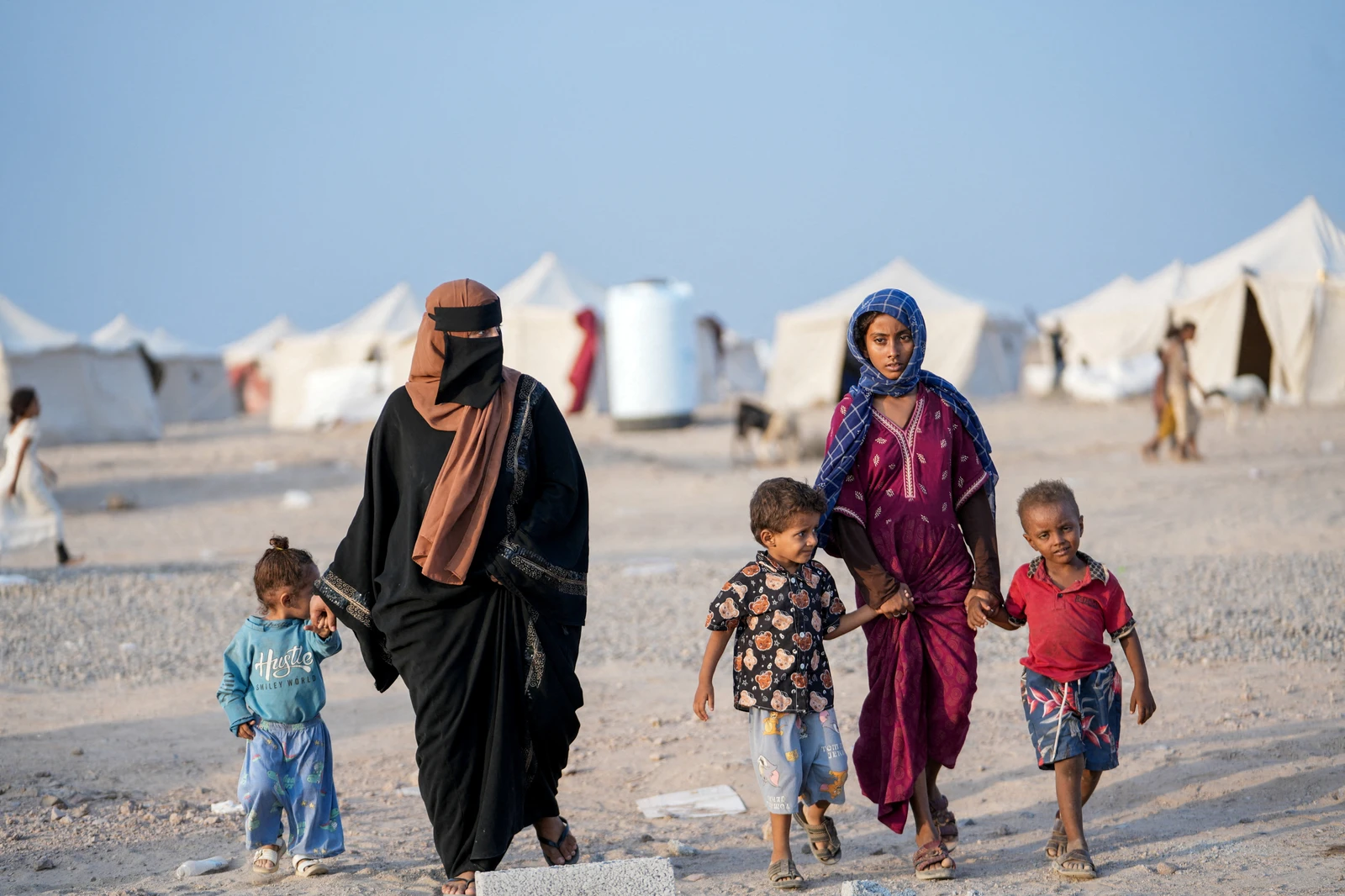 Women and children, who fled fighting between the Houthis and government forces in Red Sea coastline areas, walk at a camp for internally displaced people near Aden, Yemen, September 19, 2026. REUTERS/Stringer TPX IMAGES OF THE DAY