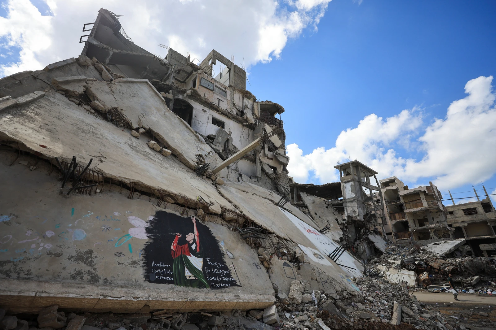 A Palestinian walks near a mural painted in honour of American rapper Macklemore, amid buildings destroyed during the war, in Gaza City. (Reuters)