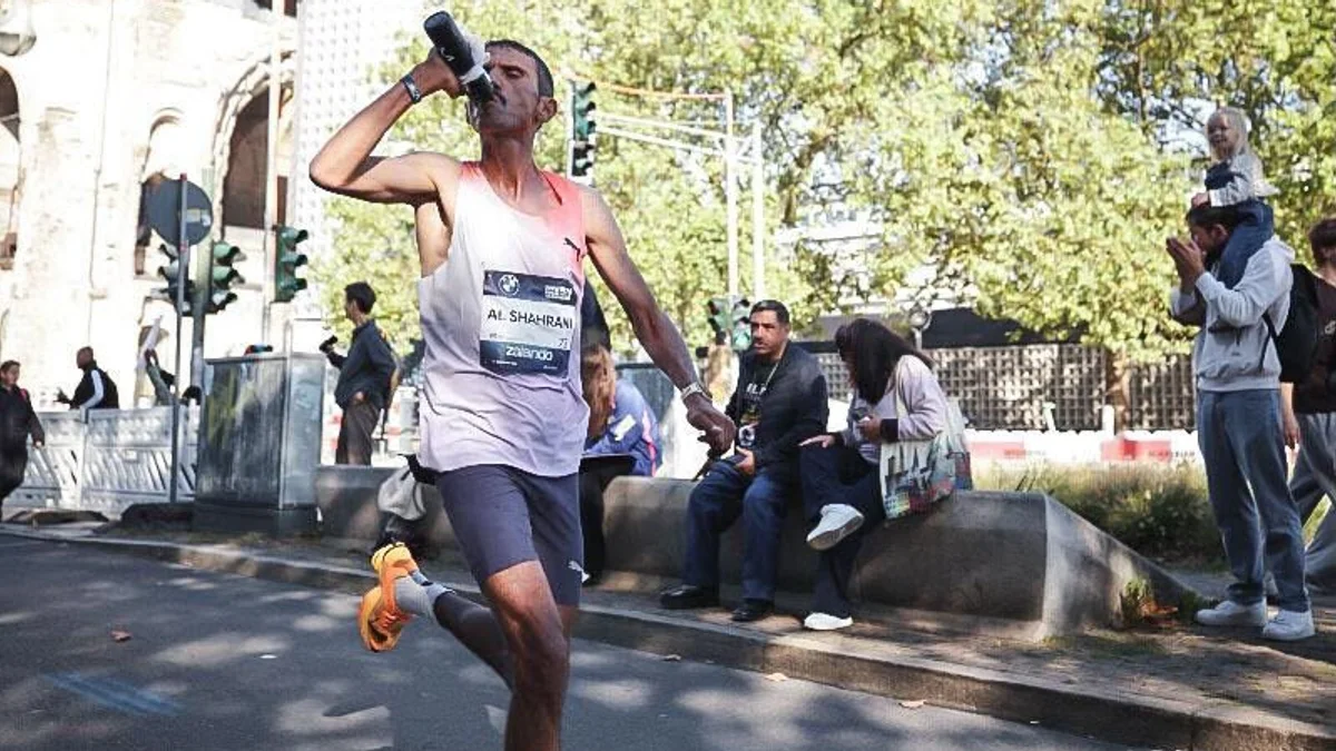 Al-Shahrani takes on fluids as he passes the Kaiser Wilhelm Memorial Church in Berlin. (Sportograf.com)