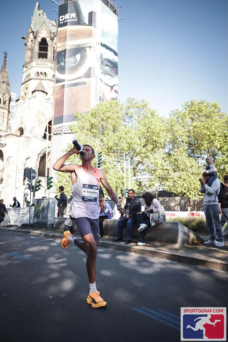 Al-Shahrani takes on fluids as he passes the Kaiser Wilhelm Memorial Church in Berlin.