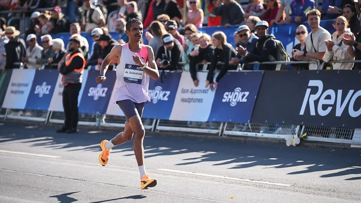 Al-Shahrani runs alongside the barriers as fans cheer from the stands. (Sportograf.com)