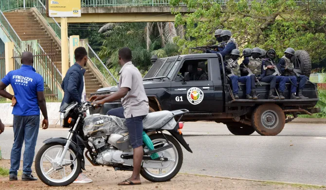 People look on as members of the Guinean Police National drive through the central neighbourhood of Kaloum in Conakry. (AFP file photo)