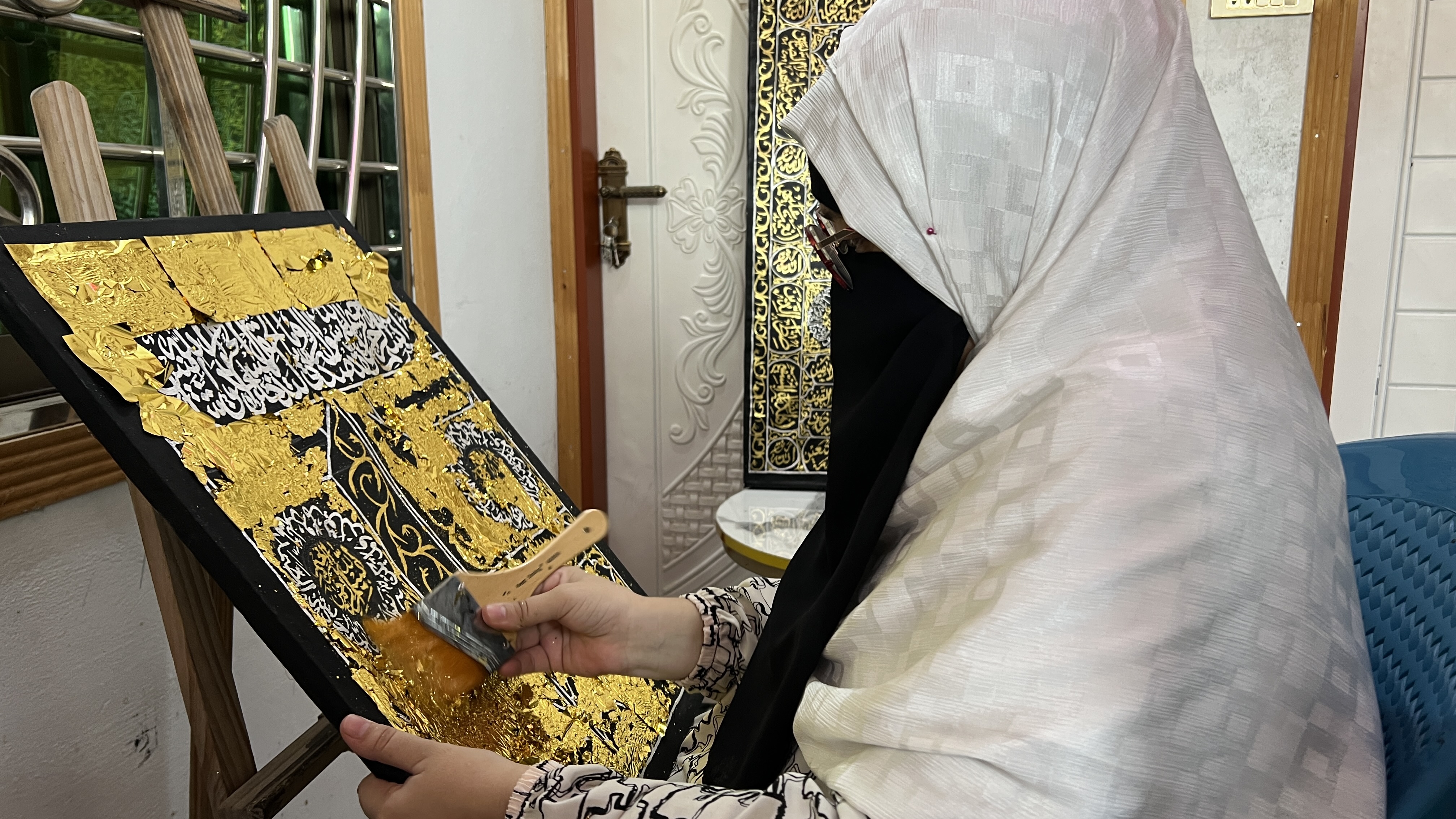 Artist Haleema Khattak meticulously applies gold leaf to a painting of the Kiswa, showcasing traditional craftsmanship and intricate design in Arabic calligraphy, at her studio in Nowshehra Khyber Pakhtunkhwa Sep 20, 2026 (AN Photo).