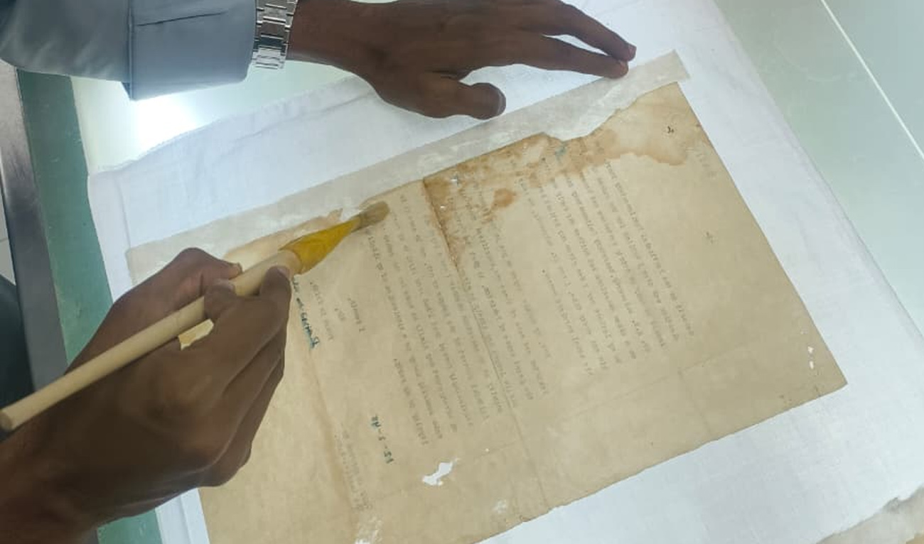 Yousuf Jameel applies a chemical solution with a brush to a document during the restoration process at the National Archives of Pakistan in Islamabad on September 28, 2026. (AN photo)