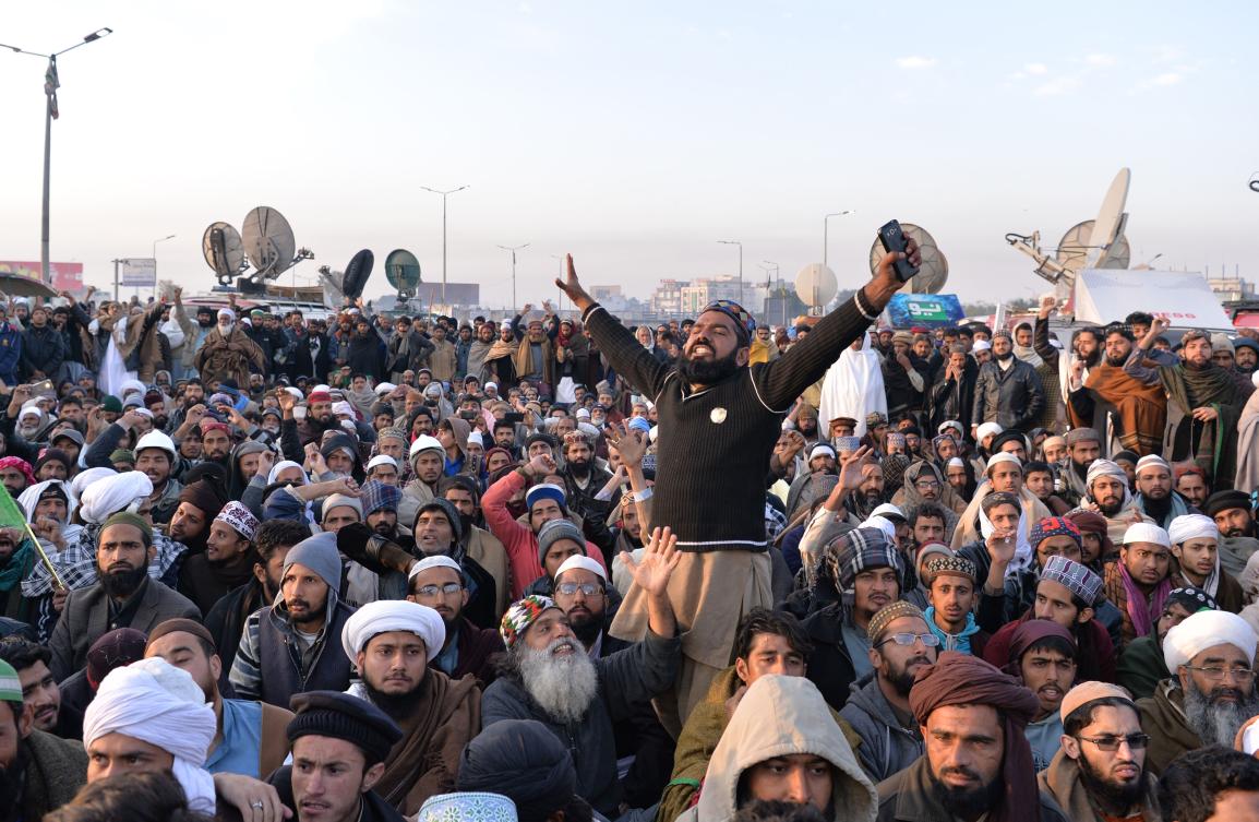 Pakistani supporters of the Tehreek-i-Labaik Yah Rasool Allah Pakistan (TLYRAP) religious group shout slogans during a press conference of their leader Khadim Hussain Rizvi as he announces the end of the sit-in protest on a blocked flyover bridge during a press conference in Islamabad on November 27, 2017. (AFP)
