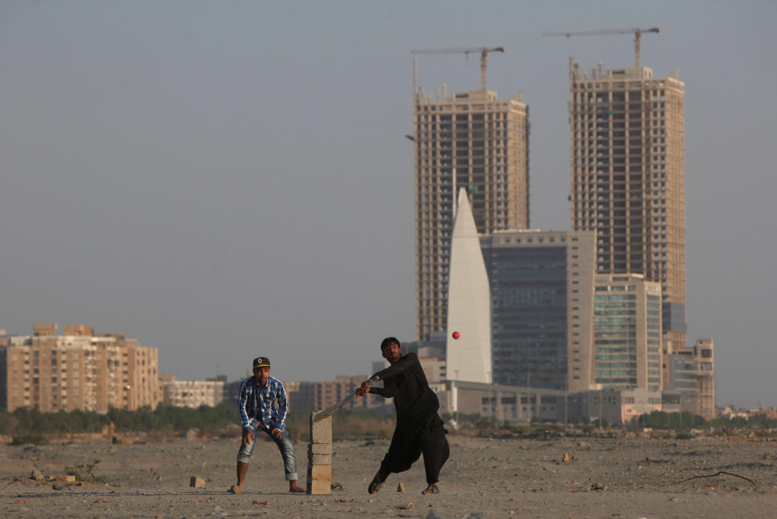 People play cricket with the Hyperstar shopping mall and under construction buildings in the background, in Karachi, Pakistan on November 20, 2017. (REUTERS)
