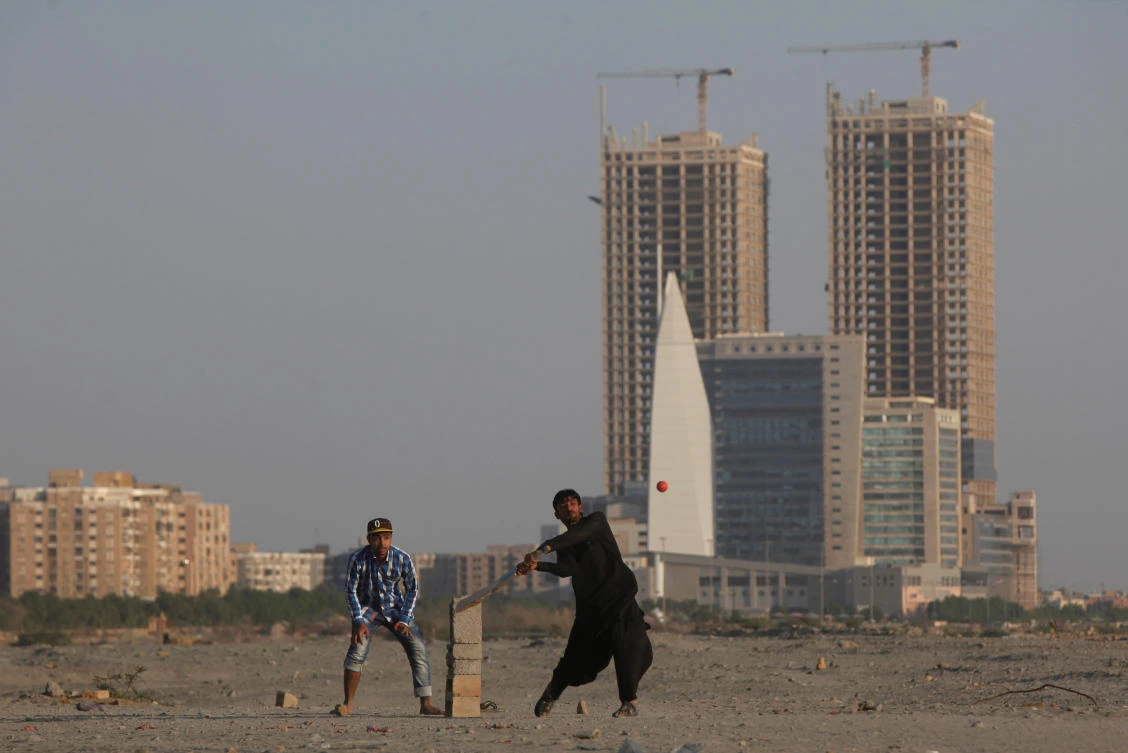 People play cricket with the Hyperstar shopping mall and under construction buildings in the background, in Karachi, Pakistan on November 20, 2017. (REUTERS)
