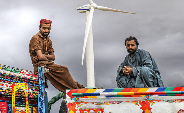 The photo shows two men sitting atop a truck in Pakistan.