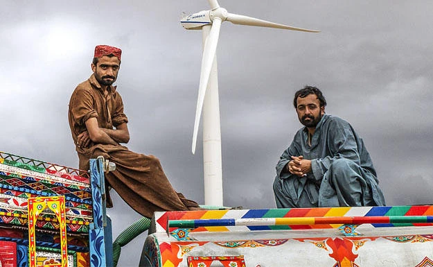 The photo shows two men sitting atop a truck in Pakistan.