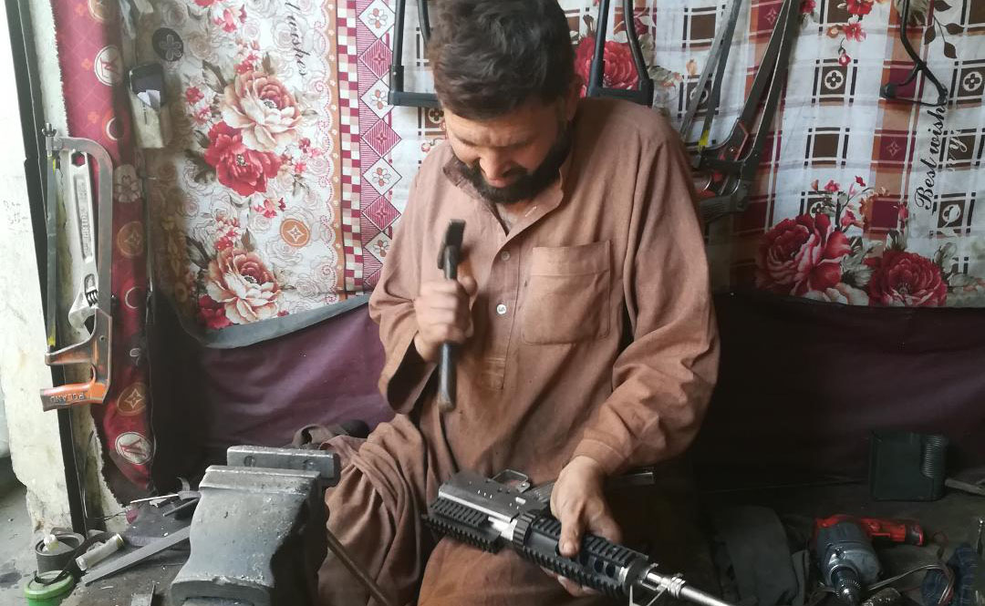 Janas Khan making an M16 rifle at his workplace in Darra Adamkhel Bazaar. (AN photo by Shahid Shalmani)