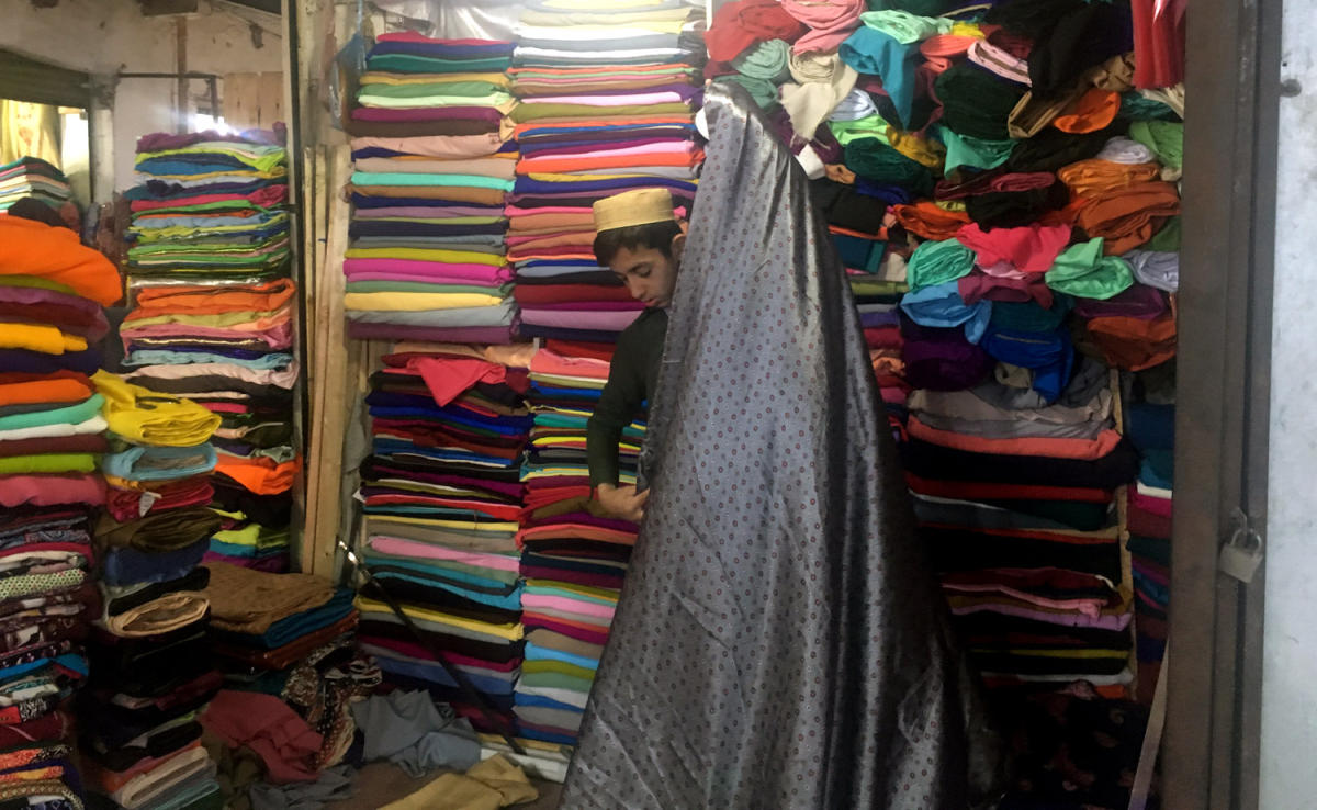 A boy in Board Bazaar (Mini Kabul) shows clothes to client. (AN photos by Abdur Rauf Yousafzai)