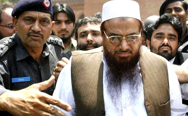 In this file photo, Police escort Hafiz Saeed, right, the head of the banned Jamaat-ud-Dawa, as he leaves after an appearance in court in Lahore on May 5, 2009. (REUTERS)