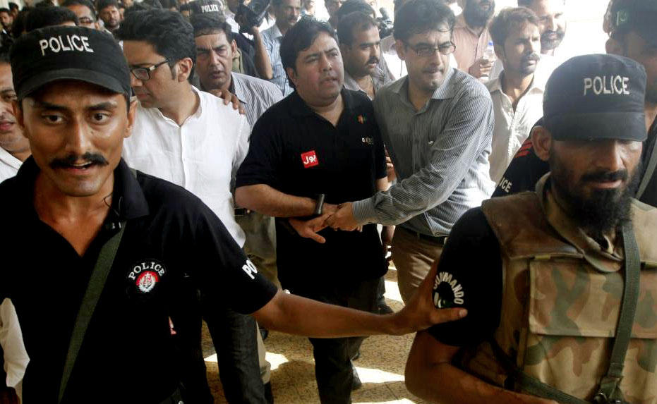In this file photo, Police and Federal Investigation Agency (FIA) officials escort Shoaib Shaikh, center, CEO of Axact, a Pakistani software company, after he was produced before a district court in Karachi, Pakistan, May 27, 2015. (REUTERS)